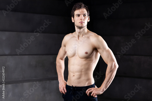 Portrait of a athleltic muscular man posing in a studio.