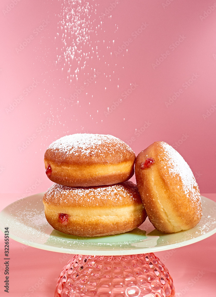 Powdered sugar falling on donuts on plate Powdered sugar falling on donuts on plate
