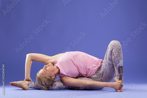 Yoga pose standing class. Slim fit girl  involved in stretching sports. Work on yourself exercise fitness exercises for women. Asana relaxation harmony balance Parivrita Janushirshasana. Copy space 