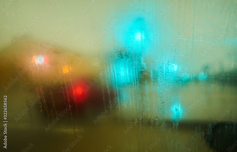 Water drops texture on a glass background with traffic lights