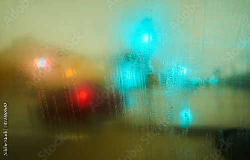 Water drops texture on a glass background with traffic lights