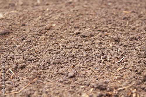 Fresh loosened soil in the garden. Top view. Close-up. Background. Texture.