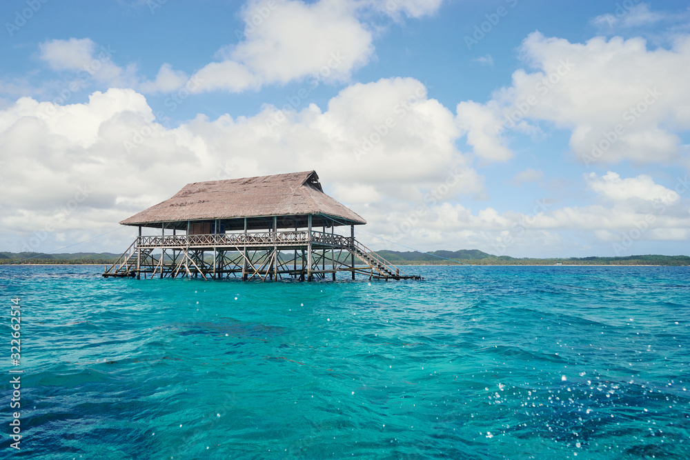 Wooden bungalow on piles in the sea.