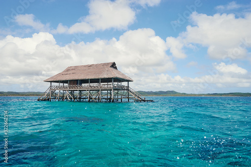 Wooden bungalow on piles in the sea.