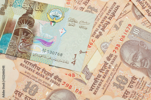 A colorful quarter dinar bank note from Kuwait close up in macro with Indian ten rupee bank notes photo