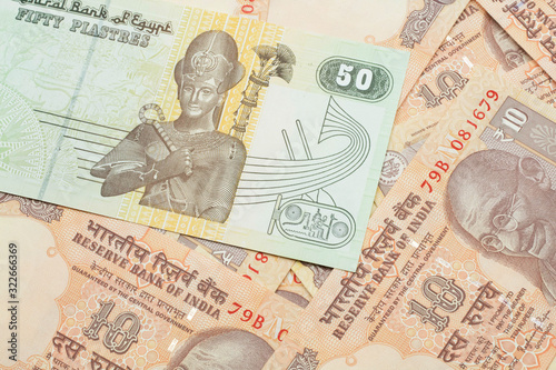 A close up image of an Egyptian fifty pisatres note with Indian ten rupee bank notes in macro photo