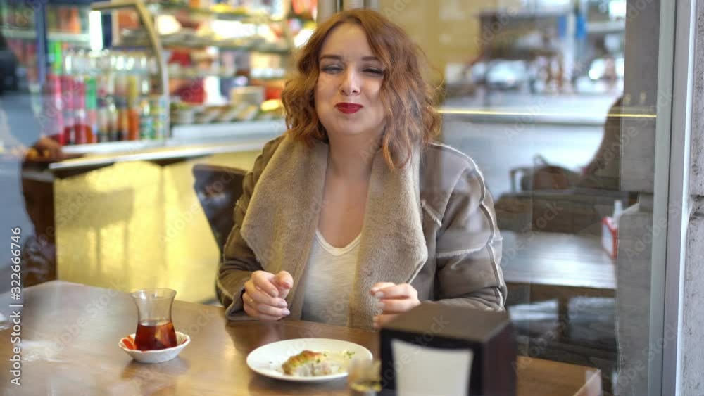 Redhead girl in the cafe eat sweets Redhead girl in the cafe eat sweets