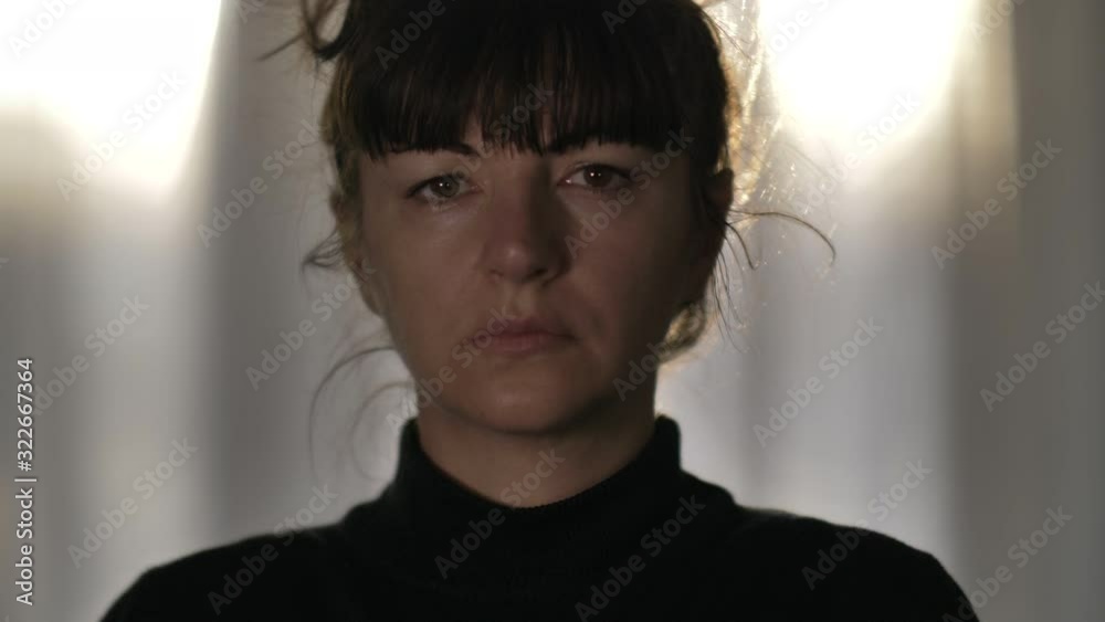 portrait of sad tired woman raises head looking at camera
