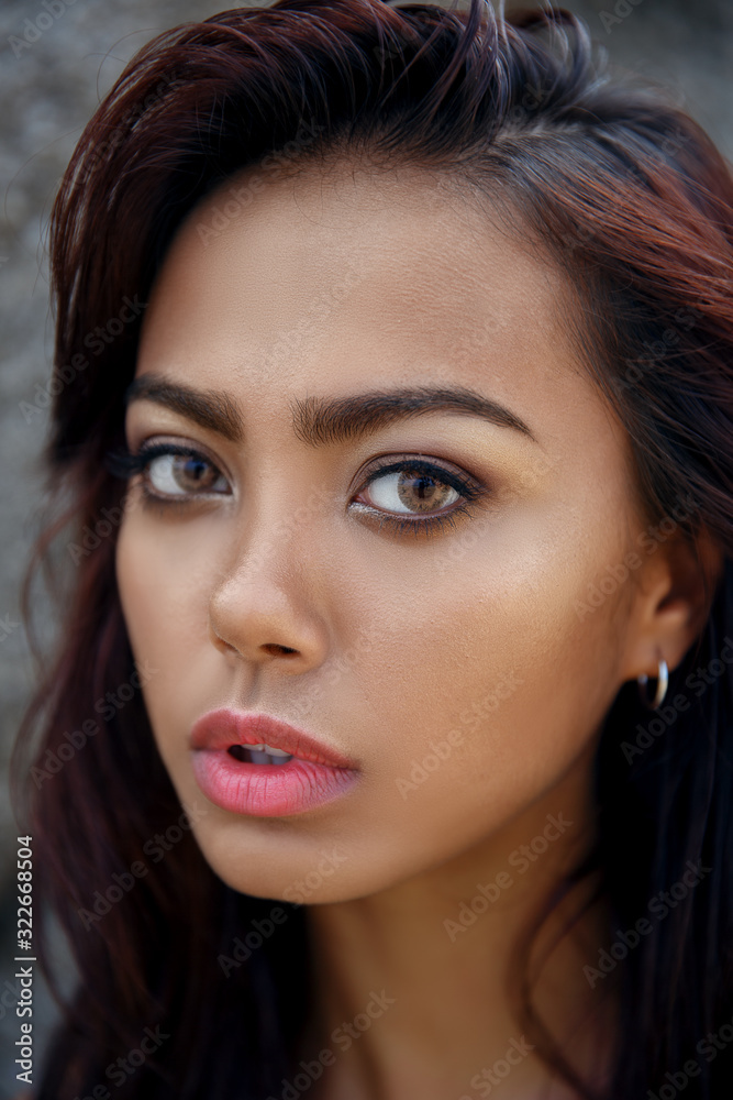 Glamour portrait of beautiful woman model with fresh daily makeup and romantic wavy hairstyle. Fashion shiny highlighter on skin, sexy gloss lips make-up and dark eyebrows