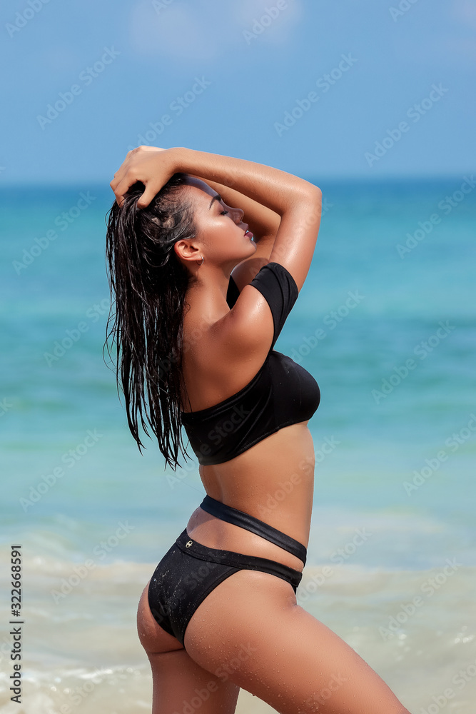 Beautiful girl posing on the beach in the hot sun, outdoor portrait