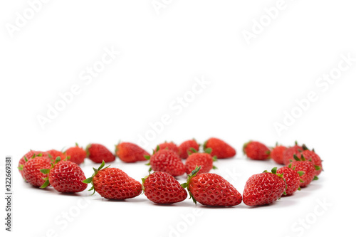 Fresh luxury Strawberry are disrupted in the group area with studio light on the white background.