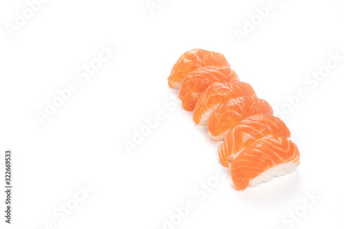 a Group of Sushi Salmon in the row on the whire background. This it the traditional Japanese food eat between raw fresh salmon and rice.