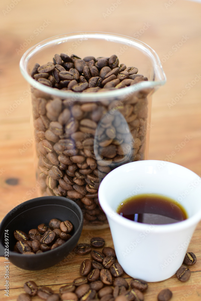 coffee beans, accompanied by cup of hot coffee coffee beans, accompanied by cup of hot coffee