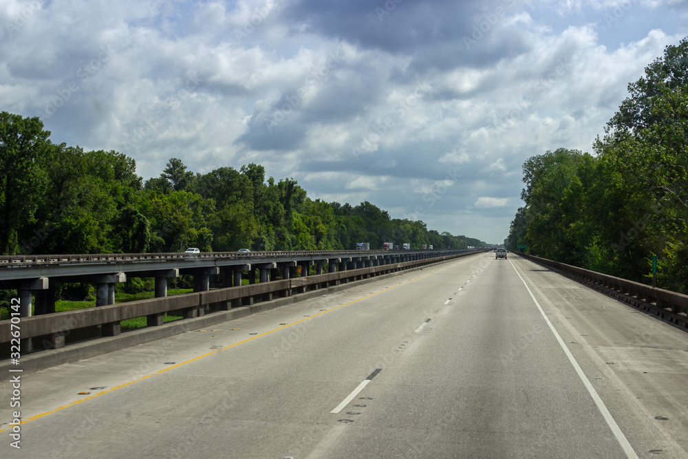 The road, a long bridge on which cars ride on a sunny summer day. Summer on the roads of Louisiana, USA