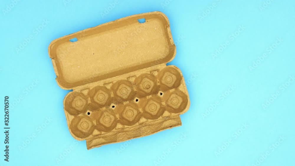 Eggs appear in cardboard box on blue background - Stop motion Eggs appear in cardboard box on blue background - Stop motion