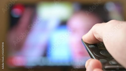 Watch TV. Close-up of a man watching and turning off the television, television ponel on the background. Interactive tv