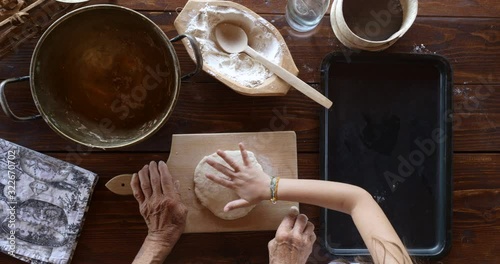 Top view preparing food. Cooking With Grandma. Beautiful Little Girl Learns How To Make Cookies.