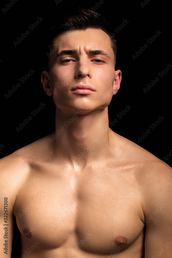 Handsome wet sport sexy stripped guy portrait with waterdrops and smoke on isolated black background Handsome wet sport sexy stripped guy portrait with waterdrops and smoke on isolated black background