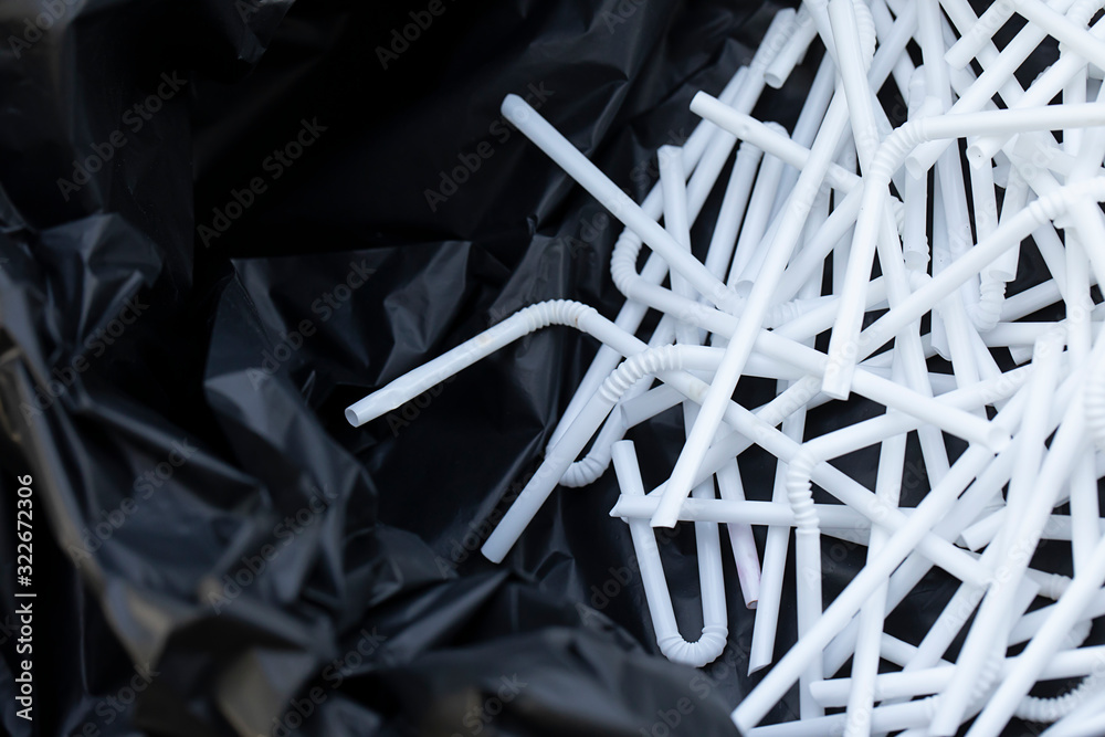 White used straws in a black garbage bag White used straws in a black garbage bag
