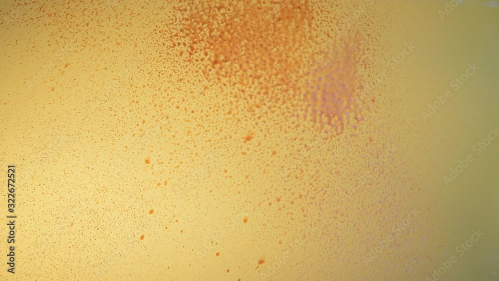 red liquid similar to blood splashes on a glass on a yellow background red liquid similar to blood splashes on a glass on a yellow background