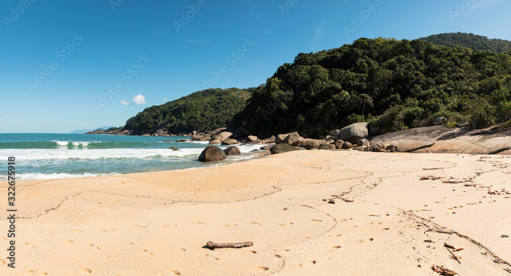 Obraz premium Panoramic view Beautiful Parnaioca beach with crystal clear blue water and stones, deserted tropical beach in the sunny Coast of Rio de Janeiro, Ilha Grande in the city of Agnra dos Reis, Brazil
