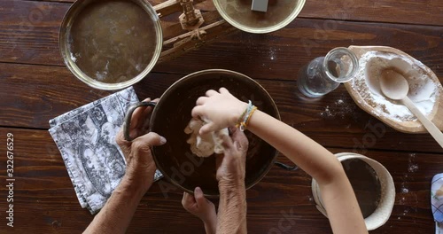 Top view preparing food. Cooking With Grandma. Beautiful Little Girl Learns How To Make Cookies.