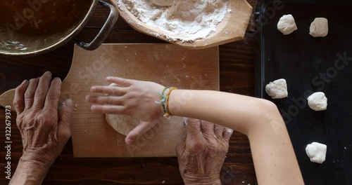 Top view preparing food. Cooking With Grandma. Beautiful Little Girl Learns How To Make Cookies.