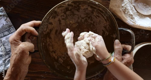 Top view preparing food. Cooking With Grandma. Beautiful Little Girl Learns How To Make Cookies.