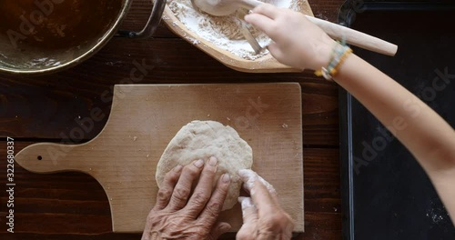 Top view preparing food. Cooking With Grandma. Beautiful Little Girl Learns How To Make Cookies.