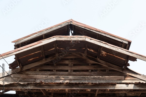 Ruins of an abandoned wooden house, rusty galvanized sheet roof