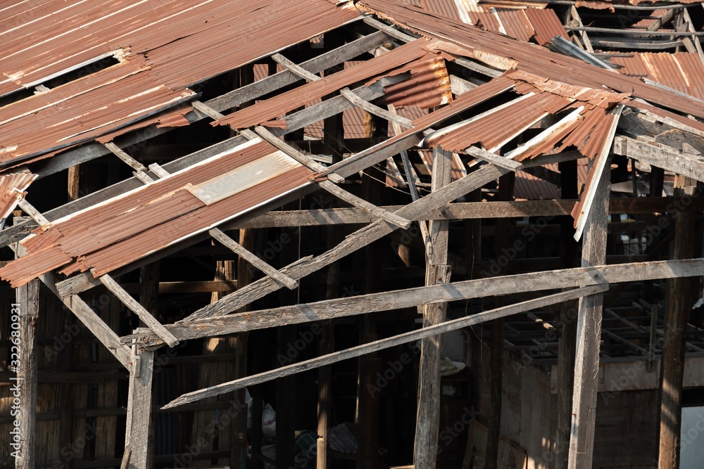 Ruins of an abandoned wooden house, rusty galvanized sheet roof Ruins of an abandoned wooden house, rusty galvanized sheet roof