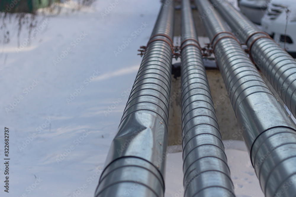 Pipes with hot and cold water. City communications. Metal pipes above the ground. Element of the water supply system. Pipes with hot and cold water. City communications. Metal pipes above the ground. Element of the water supply system.