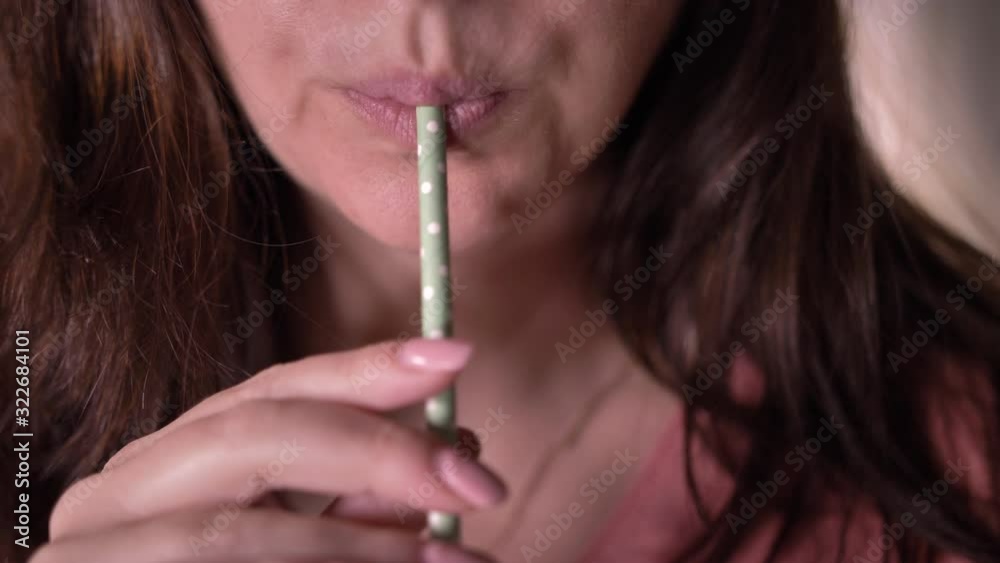 woman drinking soda from a straw, close-up woman drinking soda from a straw, close-up
