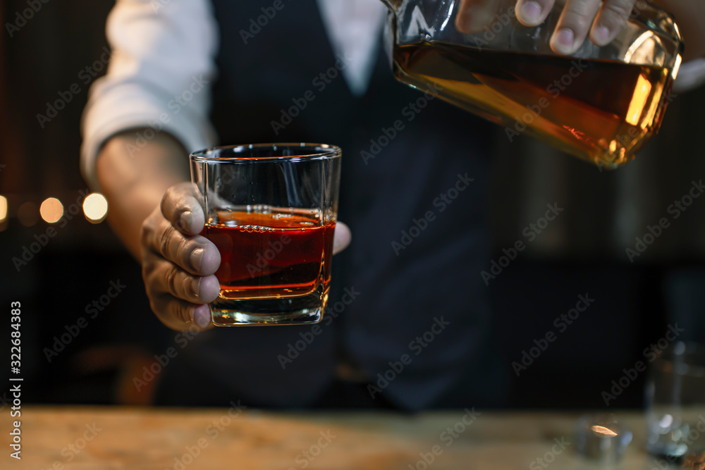 whiskey into the glass at the bar counter. whiskey into the glass at the bar counter.