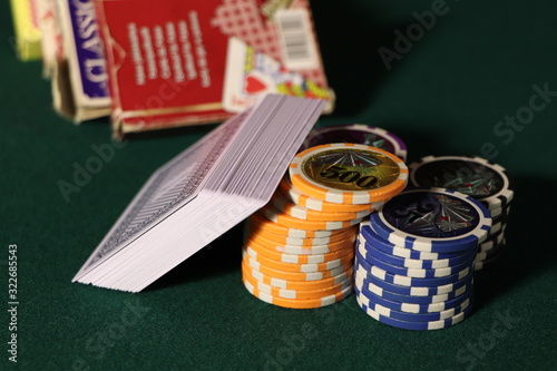 Playing cards and poker chips on a wooden table. Stack of chips for poker.