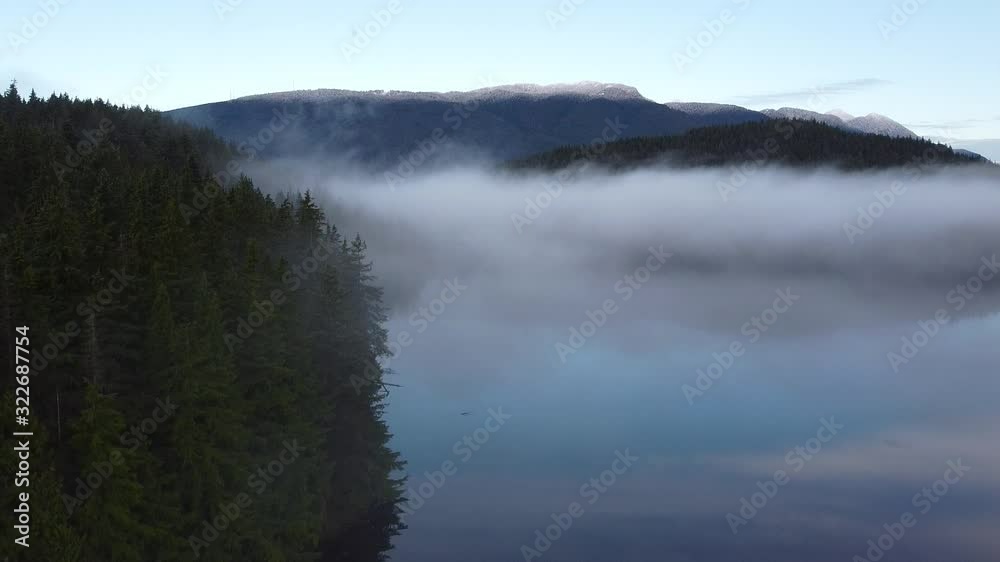Forest, lake covered with the fog in the morning and mountains far away Forest, lake covered with the fog in the morning and mountains far away