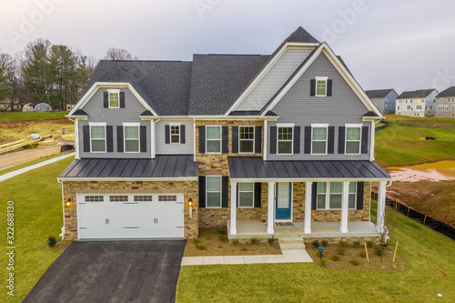 Fotografija View of custom built luxury colonial style estate home with two car garage cover