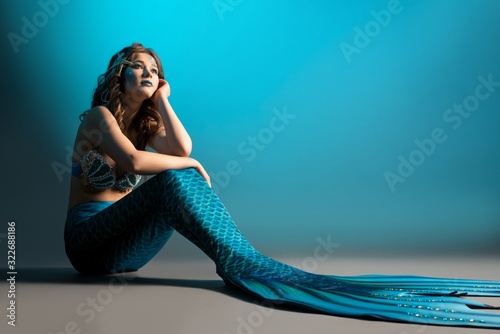 Canvastavla Woman in mermaid image sitting on the floor shot