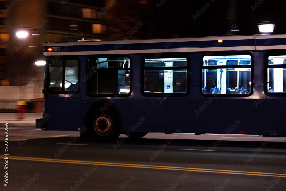 Bus Driving Down City Street At Night