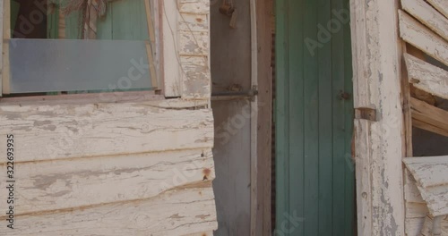 The old and rotting wooden exterior of an abandoned house in a ghost town in Outback Australia photo