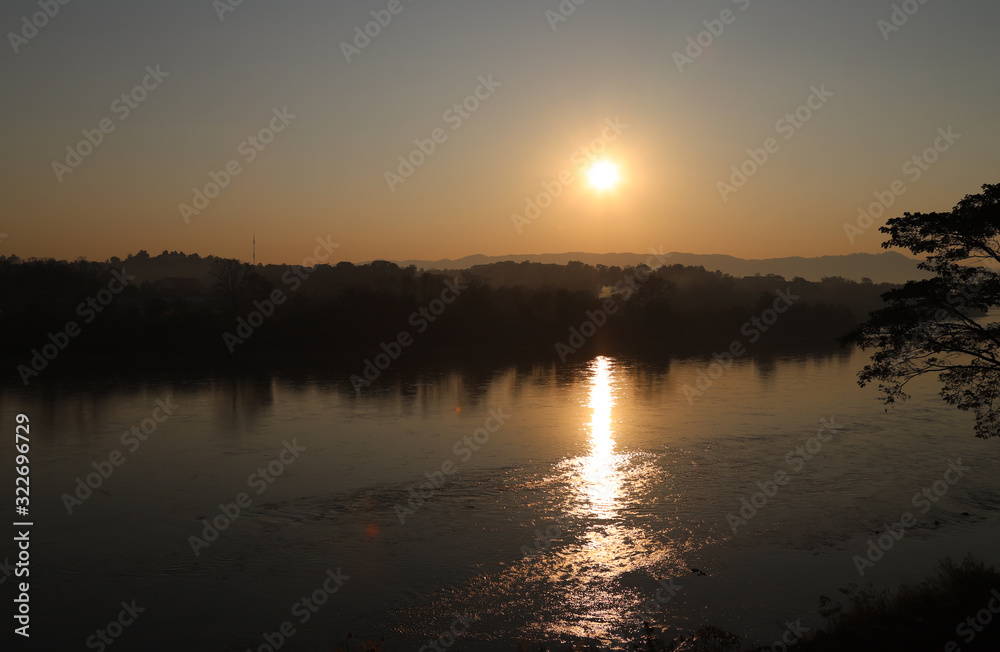 Scenery of sunrise over mountain with river water reflection.
