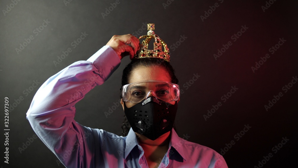African American female protected in urban black air mask wearing crown or corona on the head. Covid-19 infection concept. Depiction of deadly corona virus 2019-nCoV, pandemic in China concept. African American female protected in urban black air mask wearing crown or corona on the head. Covid-19 infection concept. Depiction of deadly corona virus 2019-nCoV, pandemic in China concept.