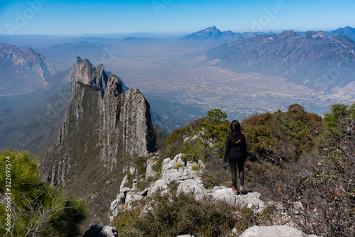 hiker young woman on top of the moutain. Monterrey Nuevo León México Aerial view of Chipinque Mountain range against cloudy sky. photo