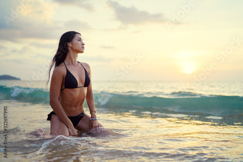 Vacation on the seashore.Young beautiful woman with long brunette hair on the sand beach.