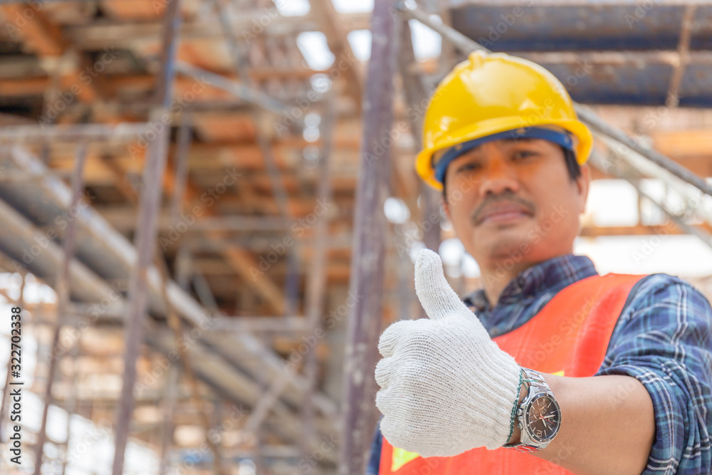 Engineer / worker man hand giving thumb up over blurred construction site, Successful concept Engineer / worker man hand giving thumb up over blurred construction site, Successful concept