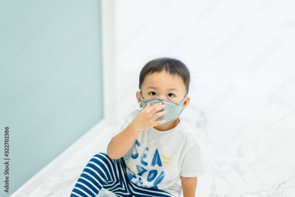 Coronavirus and Air pollution pm2.5 concept.Little chinese wuhan boy wearing mask for protect pm2.5 in Airport terminal.Toddler boy play in airport.Wuhan coronavirus and epidemic virus symptoms. Coronavirus and Air pollution pm2.5 concept.Little chinese wuhan boy wearing mask for protect pm2.5 in Airport terminal.Toddler boy play in airport.Wuhan coronavirus and epidemic virus symptoms.