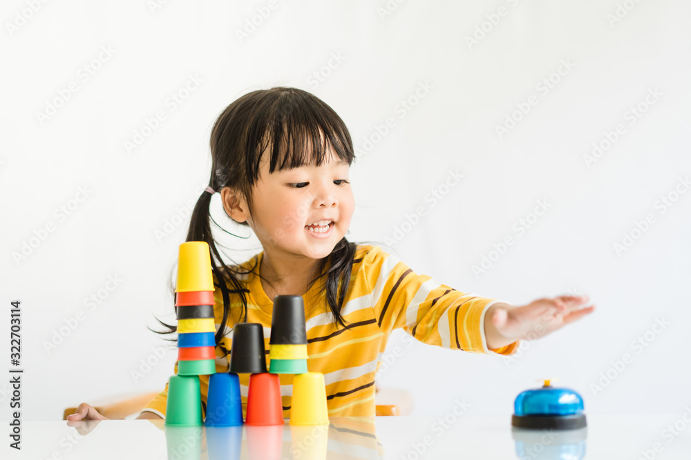 Little asian toddler girl playing stacking cups learning materials in a ...