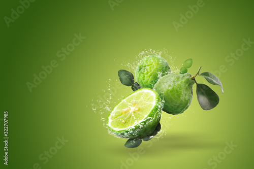 Water splashing on Bergamot fruit on green background photo