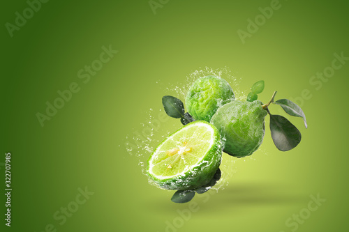Water splashing on Bergamot fruit on green background