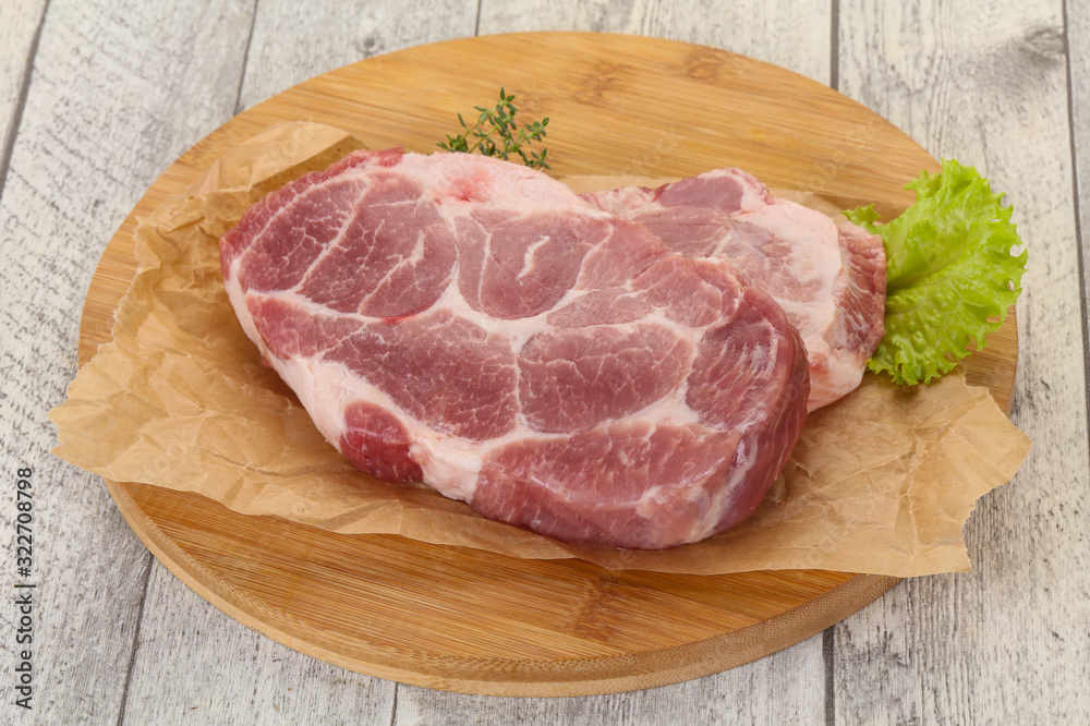 Raw pork steak over wooden board Raw pork steak over wooden board